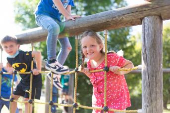 Schülerinnen und Schüler klettern auf dem Klettergerüst auf dem Schulhof