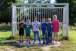 Mehrere Kinder stehen vor einem Fußballtor