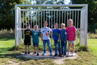 Mehrere Kinder stehen vor einem Fußballtor
