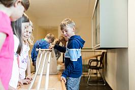 Schülerinnen und Schüler spielen gemeinsam an einer Murmelbahn
