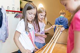 Schülerinnen und Schüler spielen gemeinsam an einer Murmelbahn