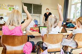 Schülerinnen und Schüler melden sich im Unterricht