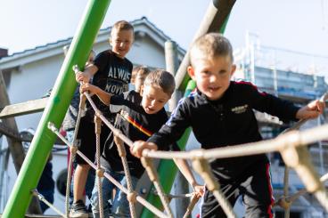 Schüler spielen auf der Wackelbrücke auf dem Schulhof